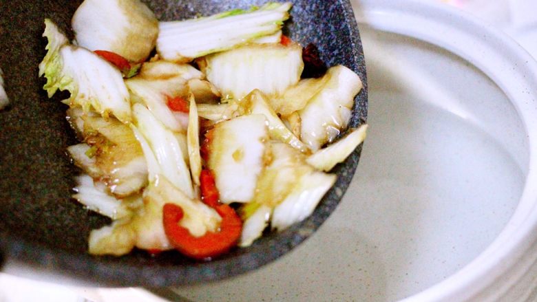 黑酱油+大白菜豆腐丸子炖海鲜,另起砂锅加入适量清水、把煸炒好的白菜帮倒入砂锅中