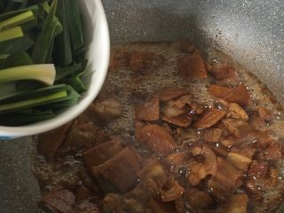  黑酱油+豆干炒肉,加入大蒜叶翻炒半分钟