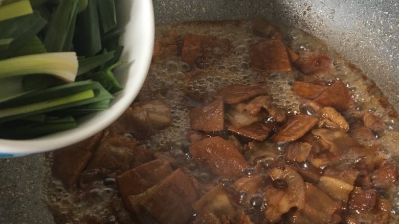  黑酱油+豆干炒肉,加入大蒜叶翻炒半分钟