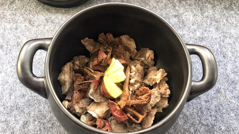 红菇排骨汤,姜切成片放入砂锅中。