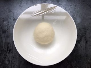 四川乐山名小吃—粉蒸肉卡饼,揉好的光滑的面团盖上保鲜膜放一边醒面半个小时。