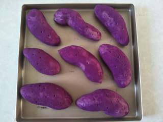 紫薯面包,摆入烤盘，留好间隙，用牙签在面包上戳几个小孔