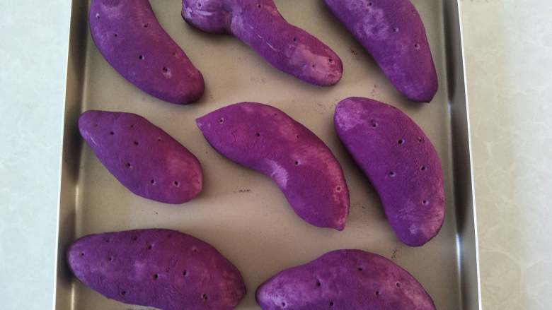 紫薯面包,摆入烤盘，留好间隙，用牙签在面包上戳几个小孔