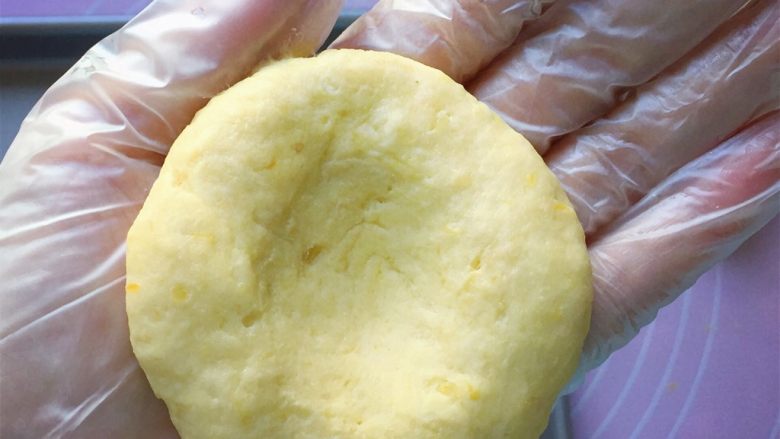 奶酪地瓜饼,取一小块面团放在手掌心，揉均匀后中间按一个凹口。