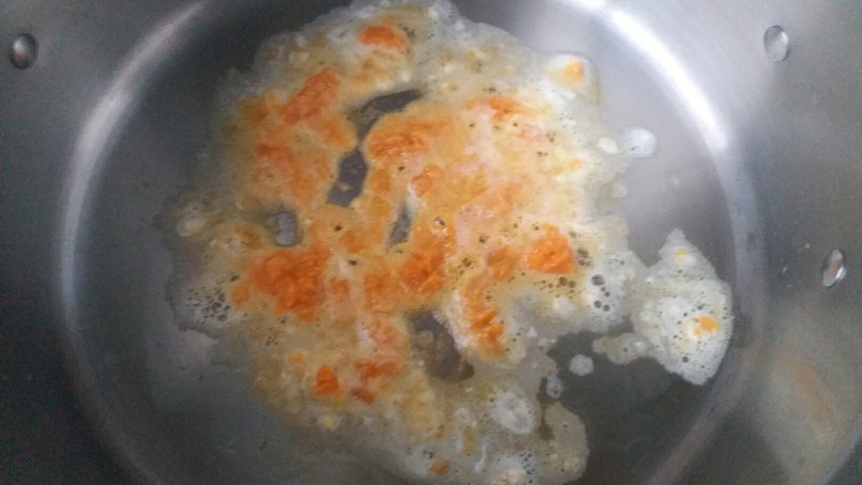 咸蛋黄腊肠豆腐,锅里油烧热后倒入蛋黄末煸炒出香味