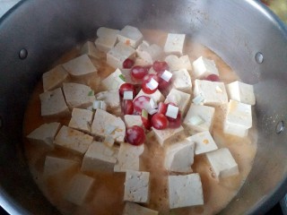咸蛋黄腊肠豆腐,放入少量葱花，腊肠段也依次放入锅里