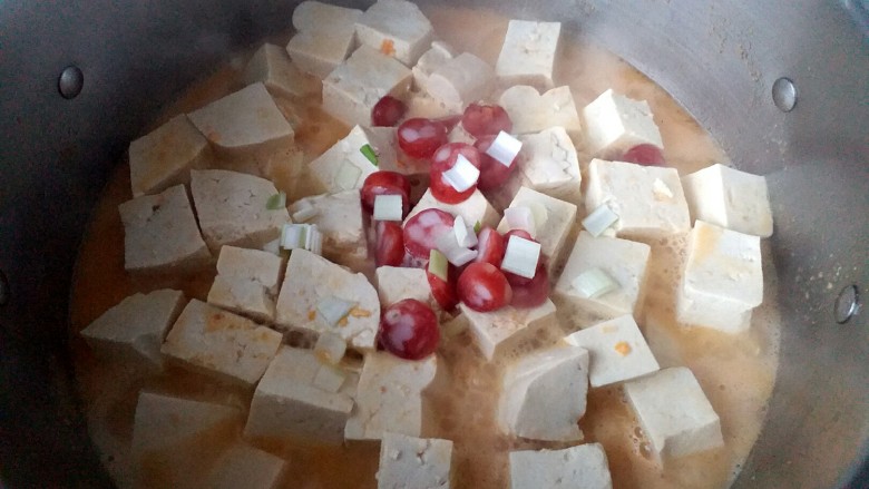 咸蛋黄腊肠豆腐,放入少量葱花，腊肠段也依次放入锅里