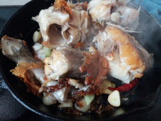 黑酱油+红烧明太鱼,将鱼盘中的鱼段再一次放入锅里