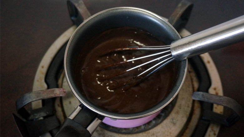 巧克力北海道戚风,小火加热，并不断搅拌，使得混合液变浓稠，成为巧克力卡仕达酱，离火。
