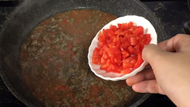 宝宝辅食之牛肉土豆泥,煮至半干时，加入甜椒，翻炒均匀。
