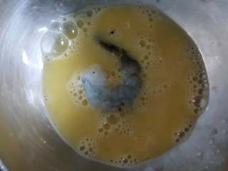 黄金凤尾虾,10.取一个腌制好的虾仁放在鸡蛋液中，使其沾满蛋液。
