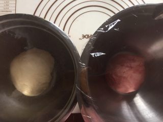 双色水立方吐司面包,再面包机还剩下五分钟时按下暂停键
取出面团排气分割成两份，其中一份加入红曲粉揉匀后分别盖保鲜膜发酵
