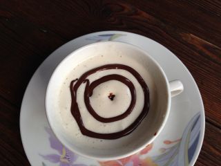 摩卡咖啡,把打好的淡奶油挤入咖啡杯中，奶油表面用巧克力酱在咖啡杯中间挤个园点，之后围着圆点画两个同心圆