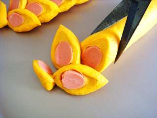 南瓜香肠麦穗面包,用剪刀倾斜着剪开片状，根部不要剪断，交错摆放，形成麦穗的样子。