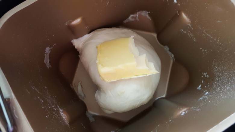 方形优格白吐司,2.将面团揉至扩展阶段时，加入黄油继续揉。