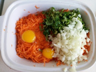 胡萝卜香菜素丸子,将鸡蛋打入，洋葱粒、香菜段倒入