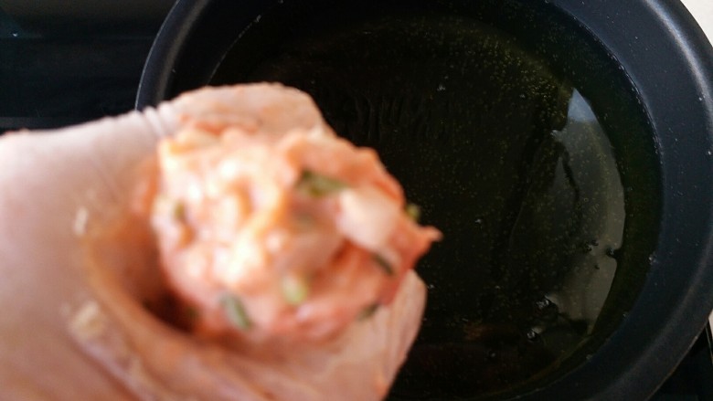 胡萝卜香菜素丸子,将做丸子的材料抓入手中，用虎口挤出里面的丸子生料成圆圆的球形，就可以入油锅里炸了