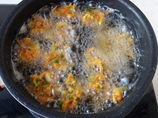 胡萝卜香菜素丸子,油温6成热炸出的丸子呈金黄色，飘在上面就可以捞出来了。