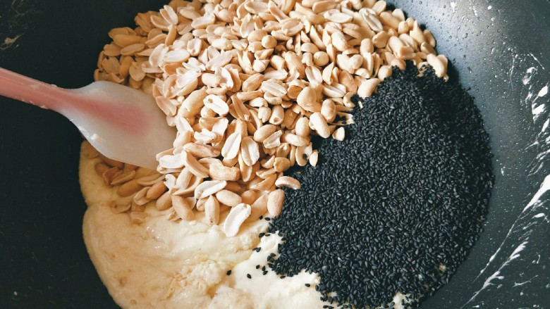 黑芝麻花生牛轧糖,放入花生仁和黑芝麻，不断翻拌至混合均匀。