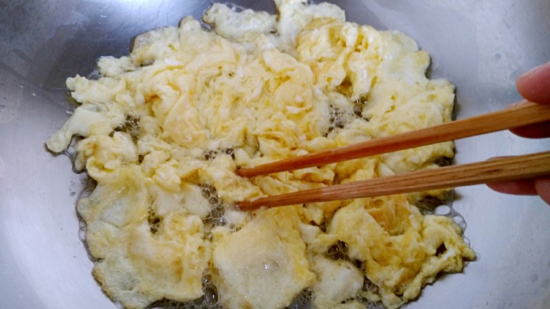 木须金针菇,待油七分热时倒入鸡蛋，用筷子分散，盛出备用。