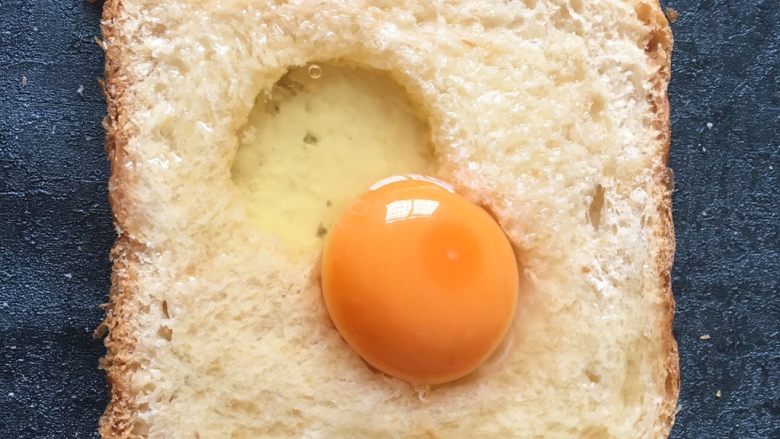 早餐+鸡蛋芝士土司面包,将鸡蛋打入洞中多余的蛋清淋在周边面包上