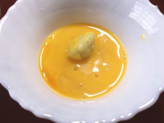 早餐+黄金窝窝头,将整形后的土豆窝窝头放入蛋液滚一圈，让其均匀沾满蛋液