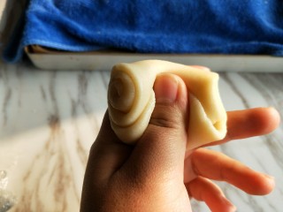豆沙菊花酥,取一块静置好的面团，大拇指从中间向下压。
