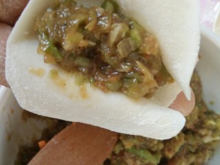 麦穗饺子,取一个饺子皮，中间放入馅。