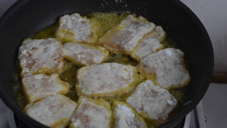 香煎巴沙鱼片,平底锅倒油，油要稍多些，烧热后放上鱼块。小火煎黄鱼块底部。