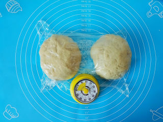 全麦奶香豆沙吐司,把面团揉几遍排气均匀分割2块，盖上保鲜膜，静置15分钟