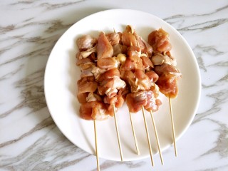 蜜汁鸡肉串,用竹签把腌制好的鸡腿串成串，洋葱不需要，只是为了增加香气，可以挤出洋葱汁