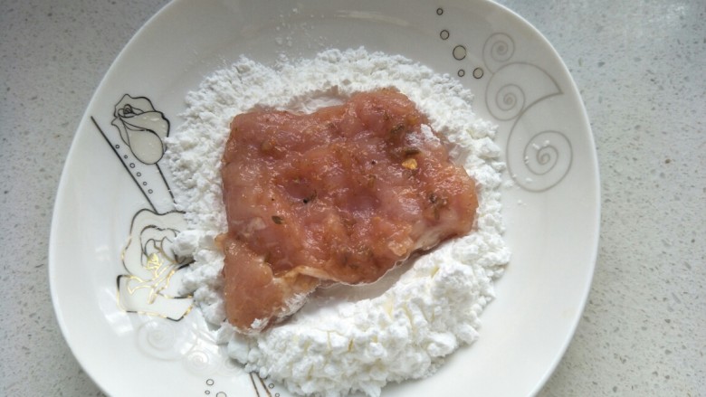 炸猪排,把腌制好的肉放淀粉中反正面沾匀。
