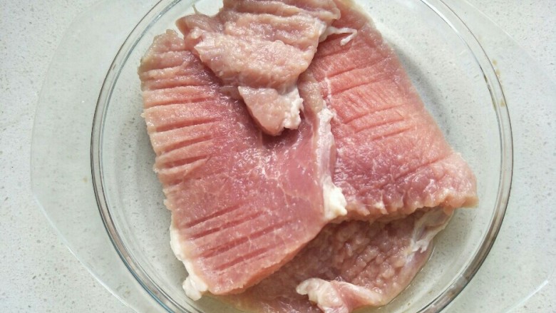 炸猪排,把拍剁好的肉放在一个盘子中。
