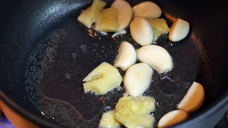 红葱头沙姜焗鸡,待油温达到7成热，放入生姜跟蒜头快速翻炒