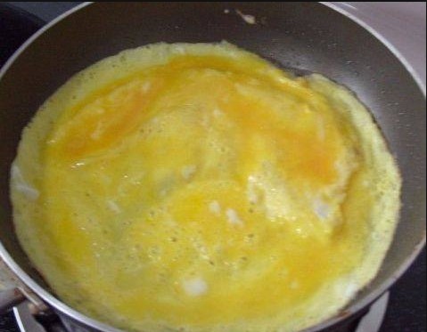 火腿肉松三明治,蛋液表面凝结时，鸡蛋饼翻个面，再煎1分钟即可盛出；