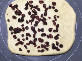 益力多蔓越莓面包块,面团擀开，在面包胚2/3撒上蔓越莓。