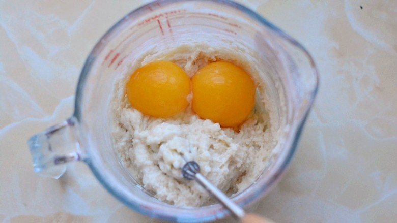 原味纸杯小蛋糕,蛋白和蛋黄分离，把蛋黄加入到搅拌好的面糊中，充分搅拌均匀

