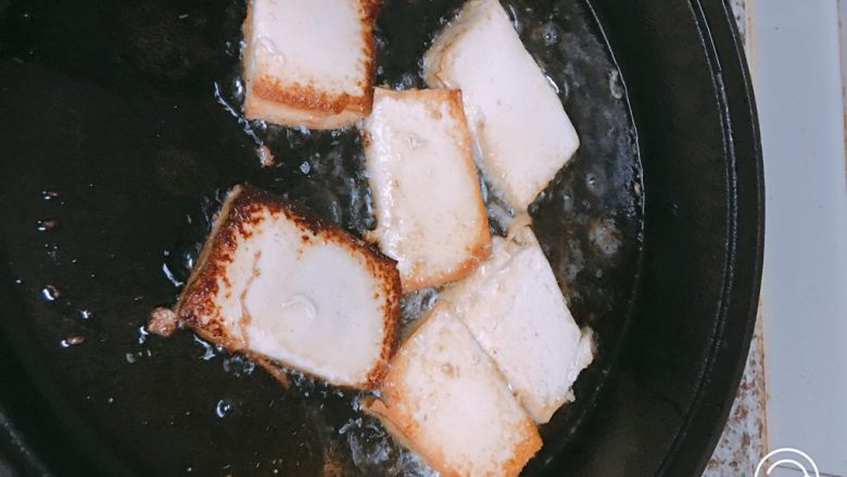 冒菜,平底锅放油，将豆腐两面煎成金黄色