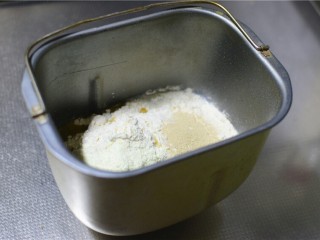 甜甜圈,将鸡蛋、牛奶、白糖、盐、高筋面粉、奶粉、酵母、玉米油依次放入面包桶内。
