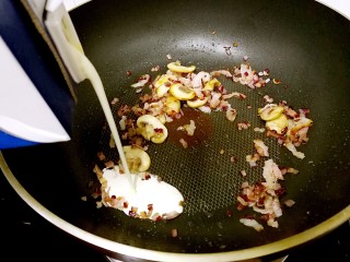 奶油蘑菇培根意粉,闻到炒锅里食材的混合香气后，倒入约30毫升淡奶油。