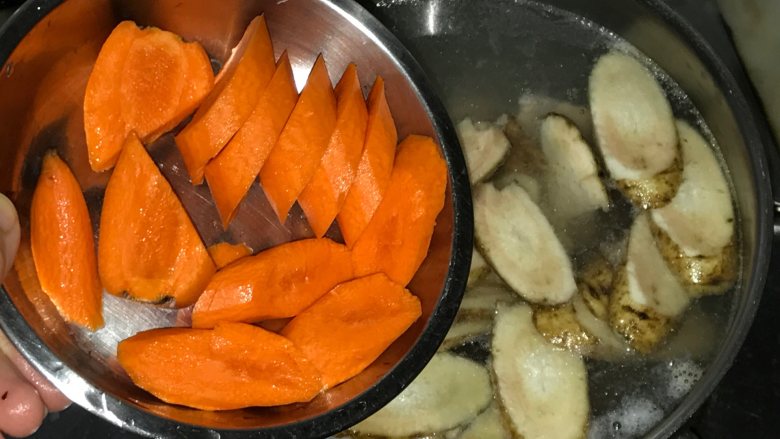 玉米胡萝卜牛蒡汤,胡萝卜去皮、切厚片放入水里。