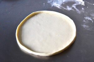 番茄芝士薄底披萨,取一份面团，擀成直径约24cm的原形
用手将面团的边折起
或狂野派的擀法参见步骤9