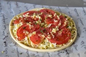 番茄芝士薄底披萨,淋上步骤5制作好的蒜碎橄榄油
撒上黑胡椒与欧芹碎