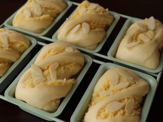 椰蓉小方包,发至两倍大即可取出来，表面喷水放杏仁片，180度预热烤箱
