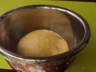 黄金南瓜蜜豆包,整理一下面团，滚圆密封，放在约28度环境下发酵