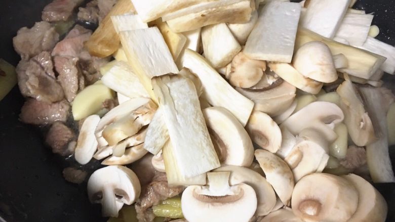青椒蘑菇炒肉片,肉片炒至变色，放蒜片，蘑菇