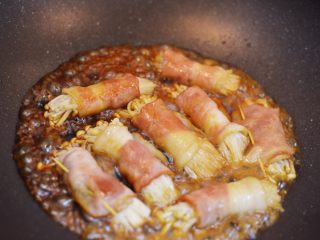 金针菇培根卷,烧开之后继续煮至汤汁收干。中间同样需要翻面，防止粘锅。