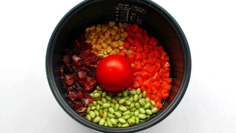懒人饭：一只番茄饭,番茄切口朝下放入中间，四周分别放上腊肠腊肉粒，玉米粒，红萝卜粒，青豆。
