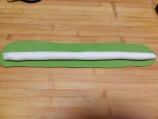 翡翠白菜饺子,绿色面团擀成长片后将白色条放在上面，包上白面团，封口捏紧