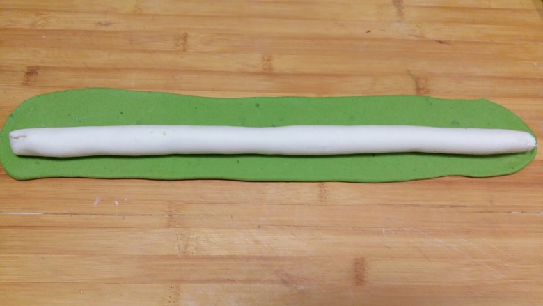 翡翠白菜饺子,绿色面团擀成长片后将白色条放在上面，包上白面团，封口捏紧